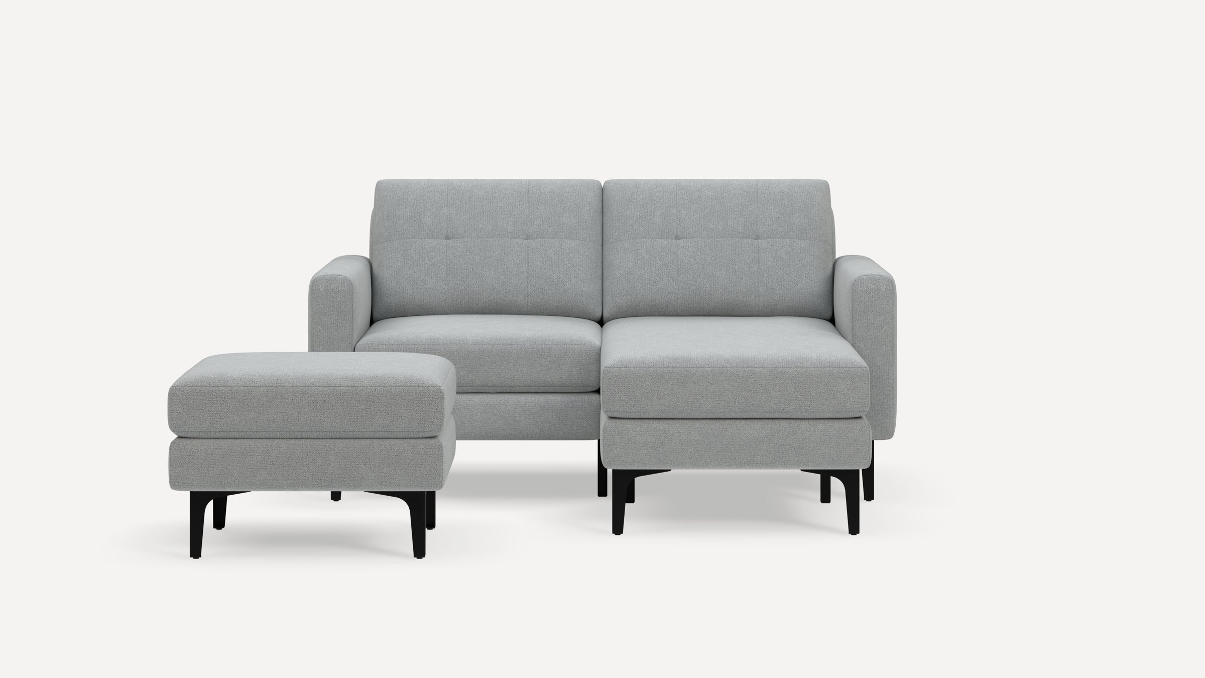 Modern light gray fabric loveseat with tufted back cushions, black legs, and a matching square ottoman on a white background.