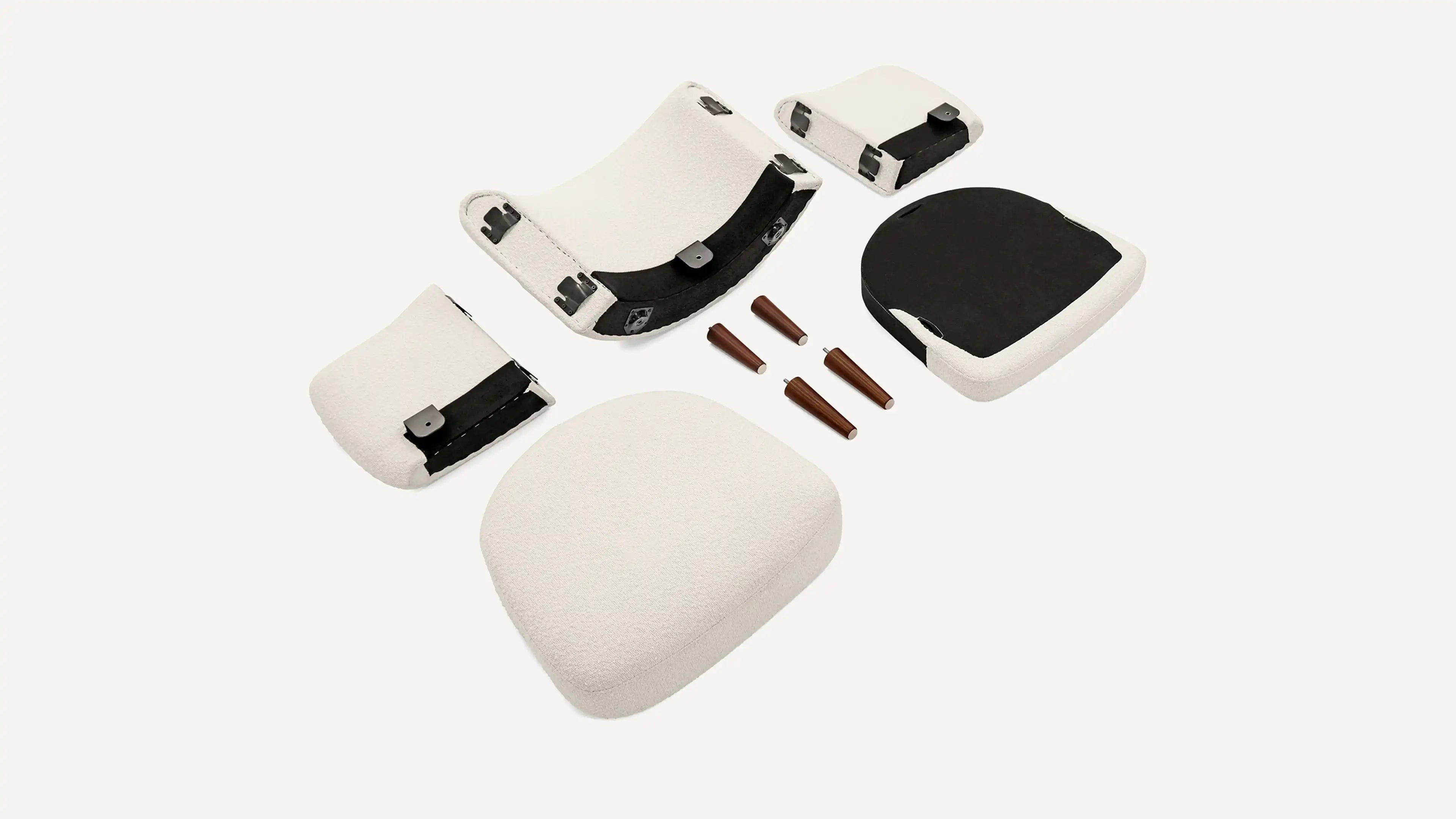 Disassembled white cushioned chair parts and four wooden tapered legs arranged on a plain background.