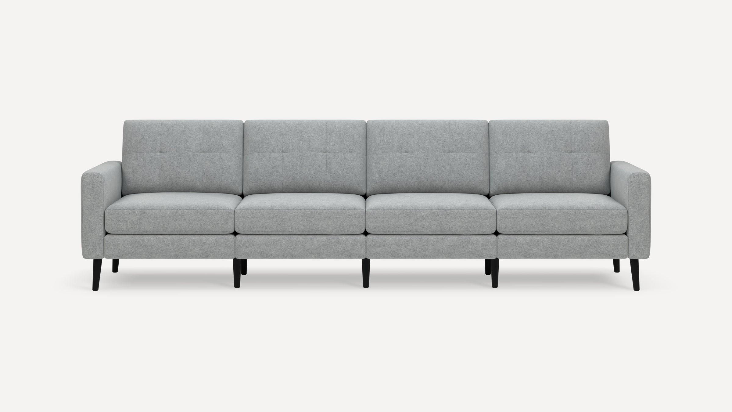 Light gray modern four-seat sofa with tufted back cushions and black tapered legs on a white background.