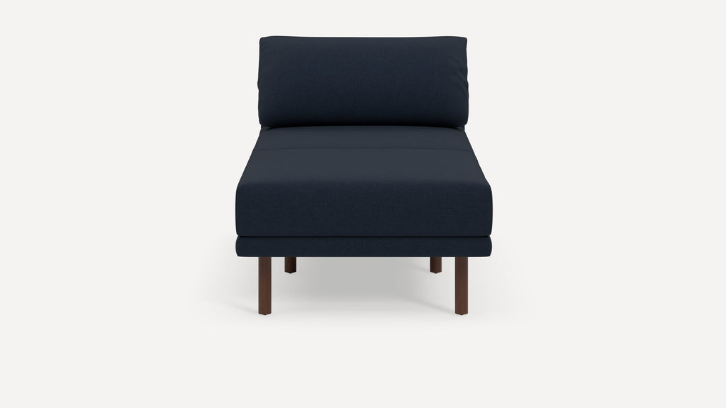 Front view of a modern dark blue armless chaise lounge chair with wooden legs on a white background.