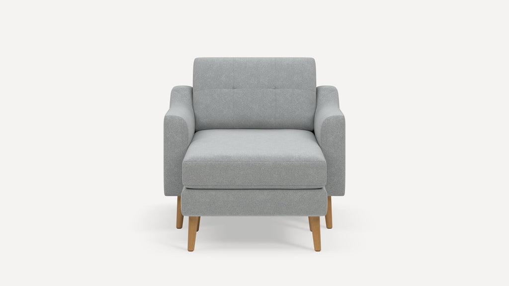 Front view of a modern light gray upholstered armchair with wooden legs and a cushioned seat and backrest.