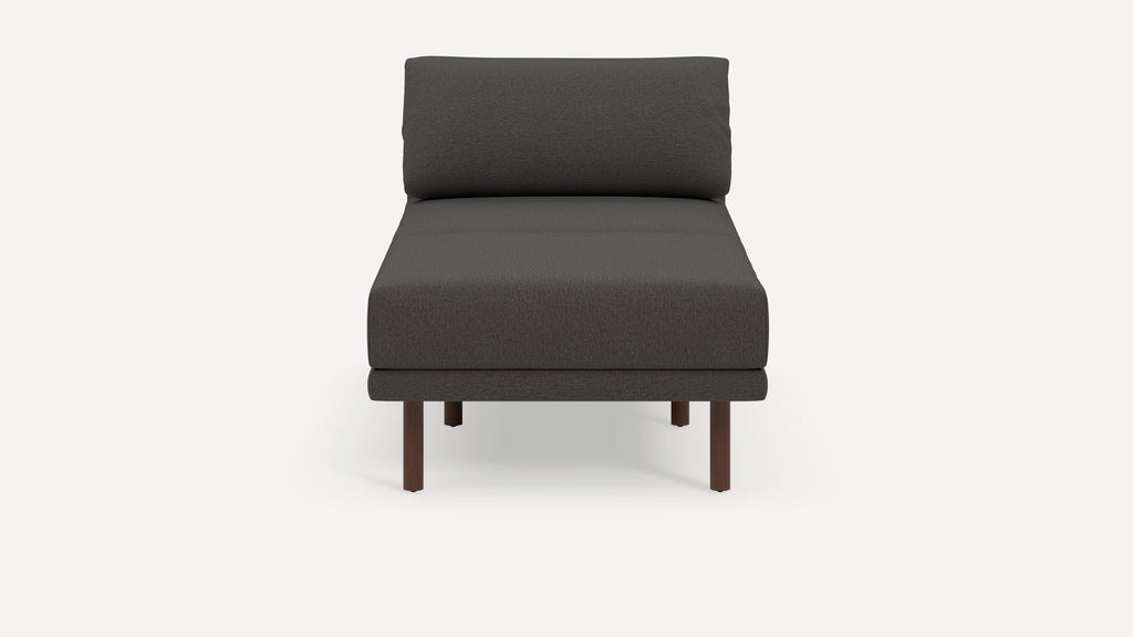 Modern dark gray armless lounge chair with cushioned seat and backrest, supported by four wooden legs.