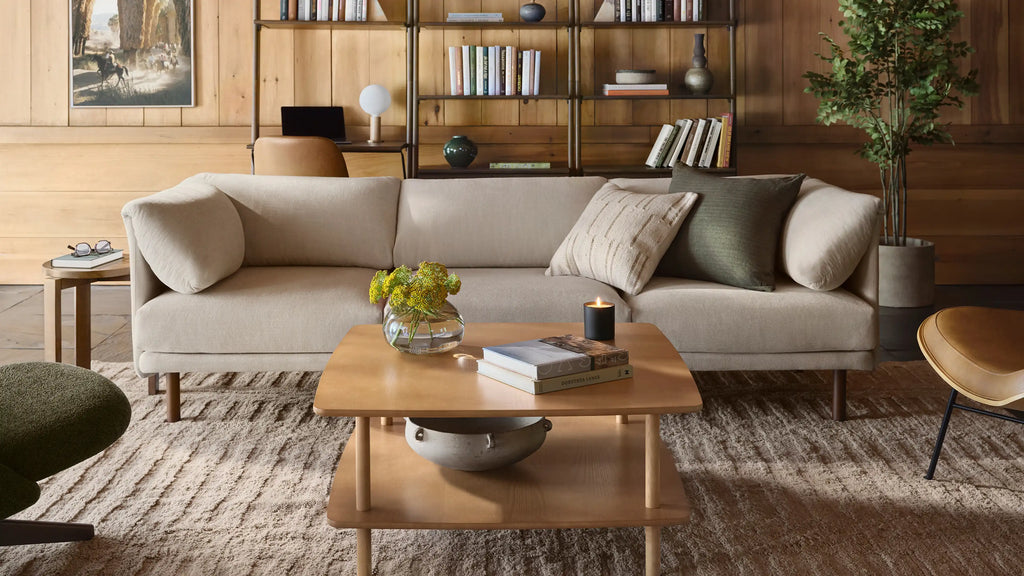 modern living room with beige sofa, beige armchair, wooden coffee table, and green plant on the side table