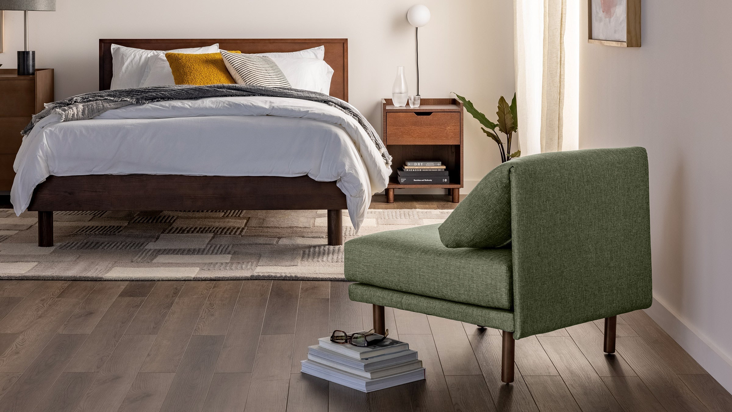 a bedroom with a bed, nightstand, and chair