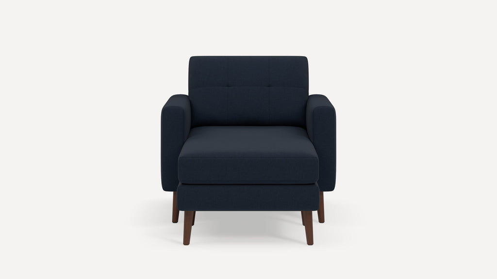Front view of a modern dark blue upholstered armchair with wooden legs and a cushioned seat and backrest.