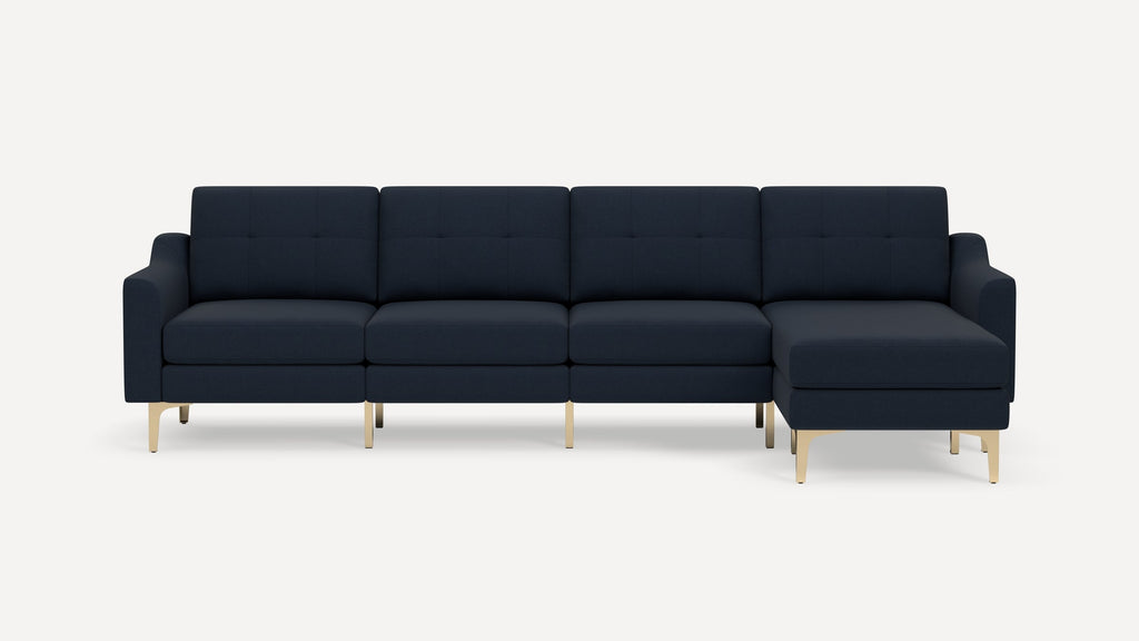 Modern dark navy blue sectional sofa with tufted cushions and gold metal legs on a white background.