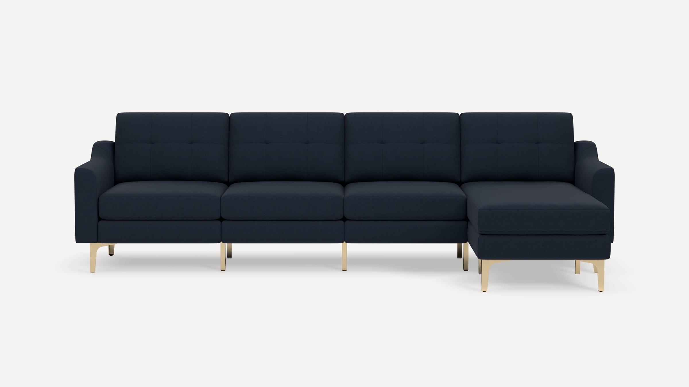 Modern dark navy blue sectional sofa with tufted cushions and gold metal legs on a white background.