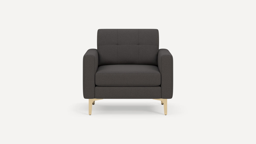 Front view of a modern dark gray armchair with padded cushions and light beige angled legs on a white background.