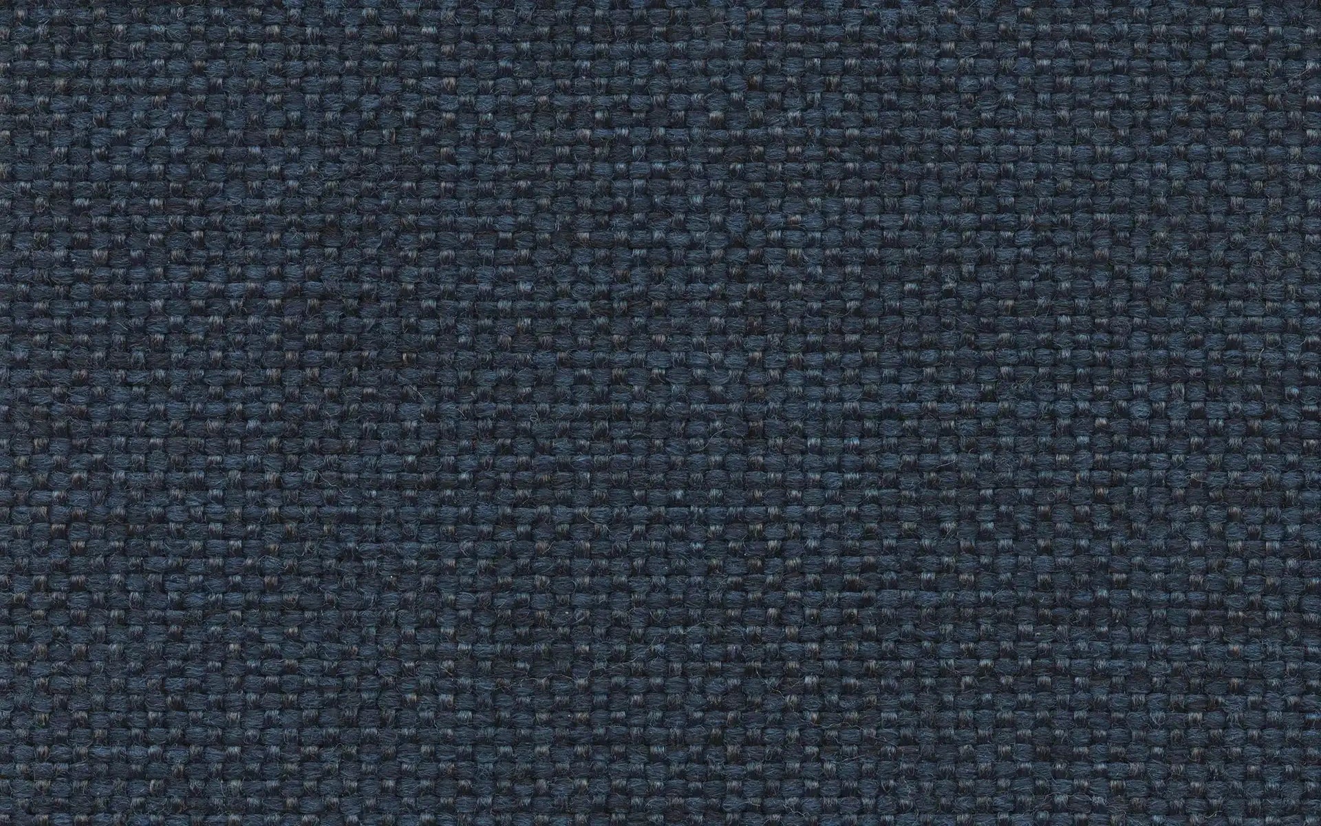Close-up image of dark blue woven fabric with a textured, grid-like pattern and subtle variations in thread thickness.