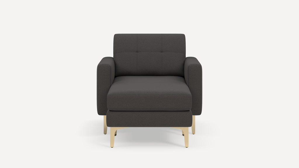 Front view of a modern dark gray armchair with cushioned seat, tufted backrest, armrests, and light wooden legs against a white background.