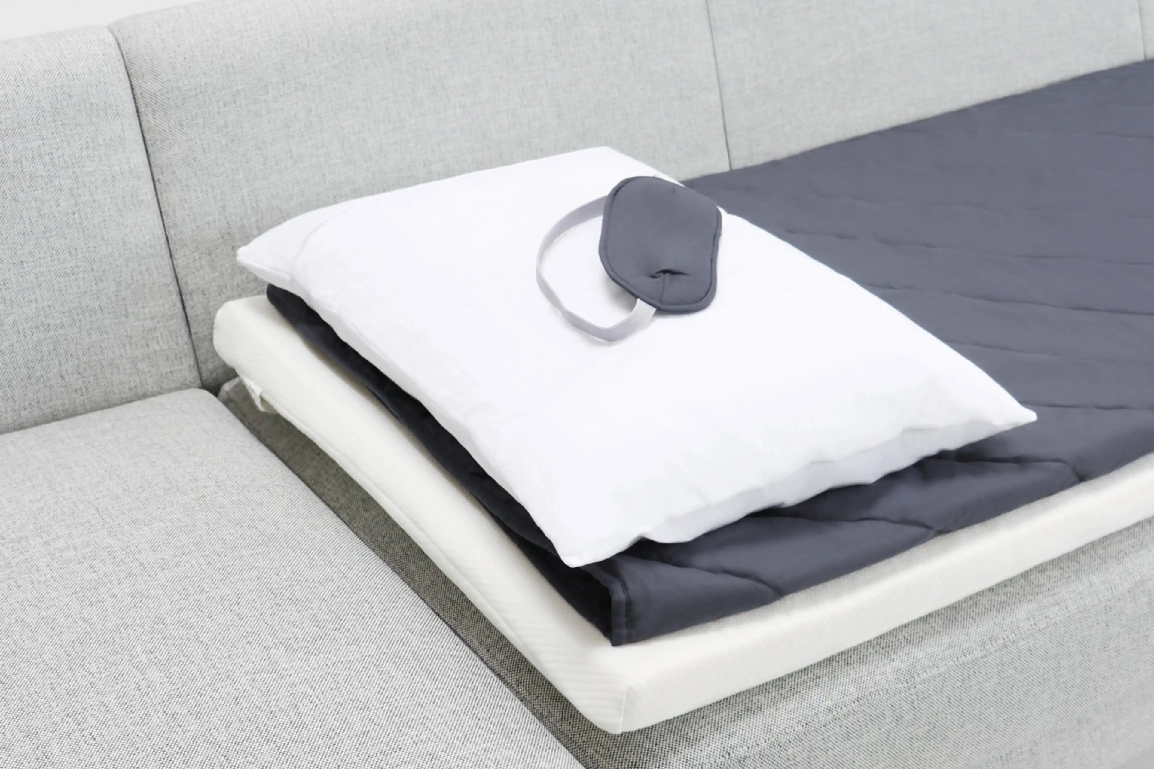 a white pillow on a gray couch