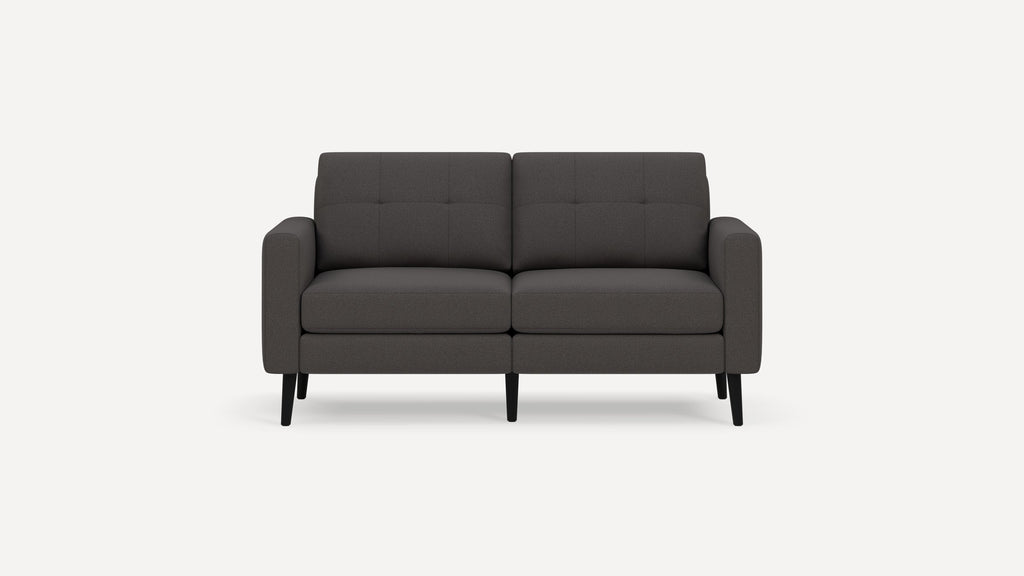 Modern dark gray two-seater sofa with tufted back cushions and black tapered legs on a white background.