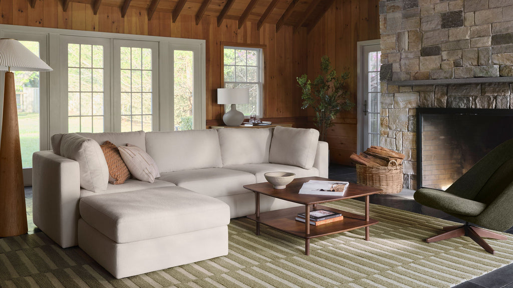 a living room with a large sectional sofa and a green chair