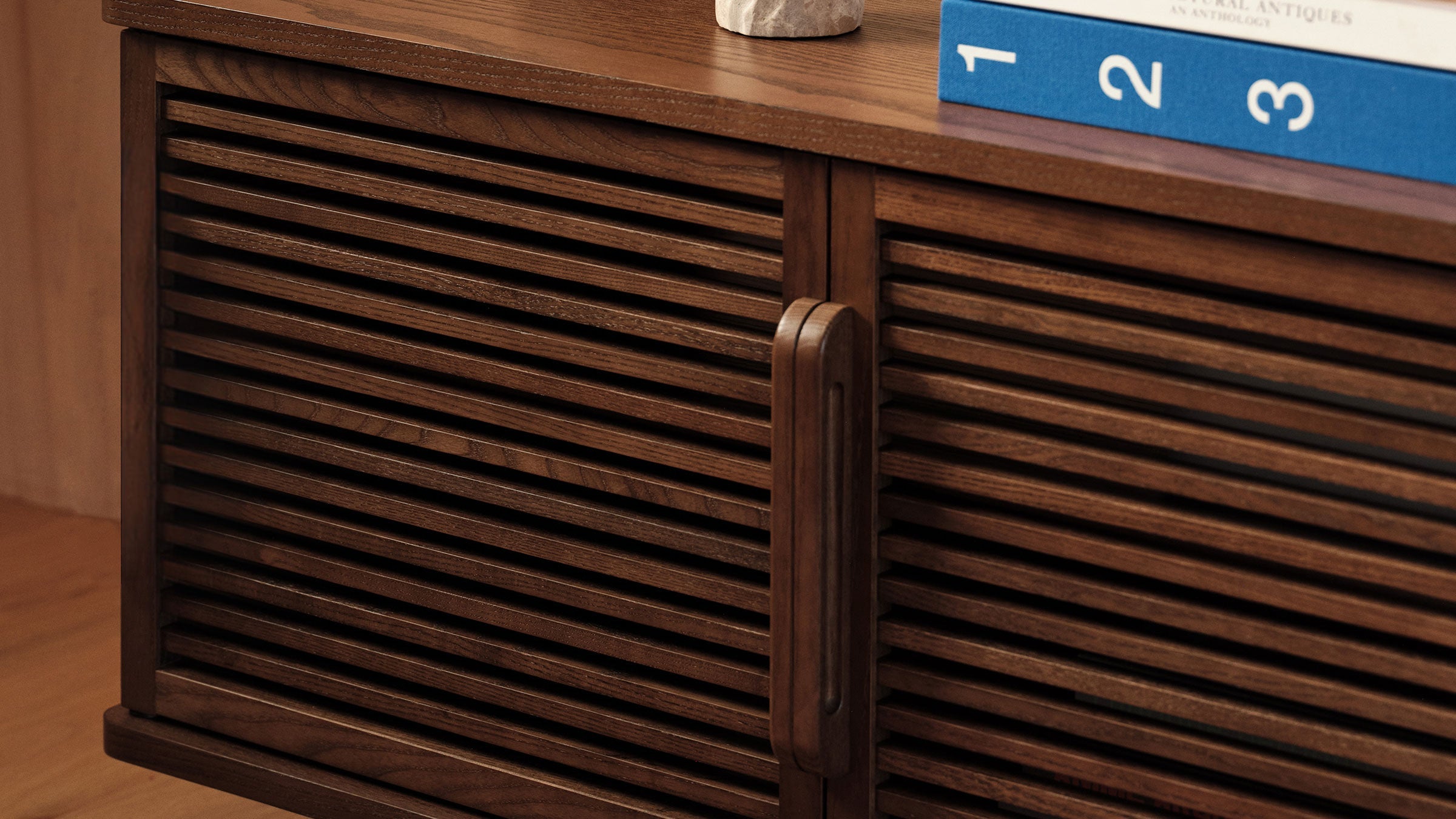 a close up of a wooden cabinet with a book on top