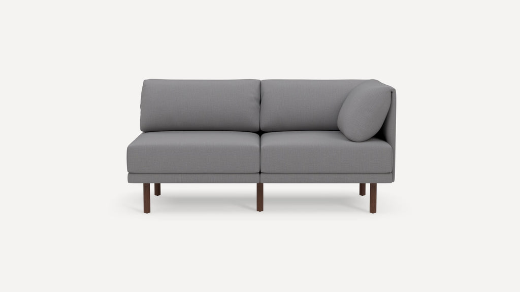 Modern light gray two-seater sofa with wooden legs and a cylindrical cushion on one side, set against a plain background.