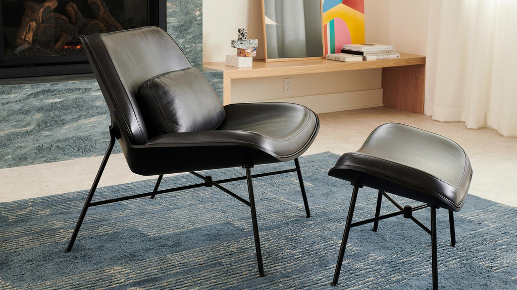 modern black leather lounge chair with matching ottoman and matching ottoman, featuring a modern fireplace and modern artwork