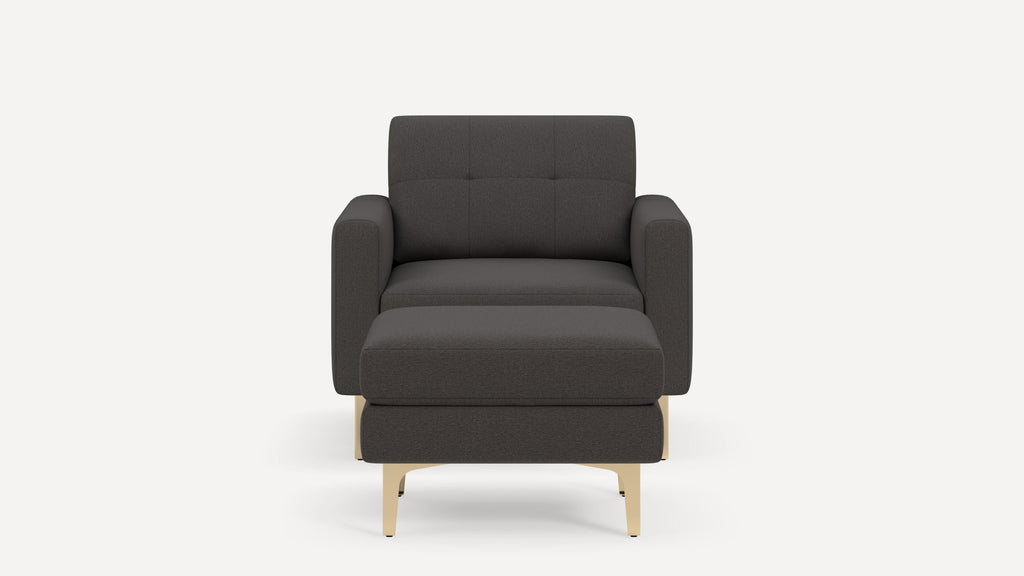 Front view of a modern dark gray armchair with matching ottoman and light wood legs, against a plain white background.