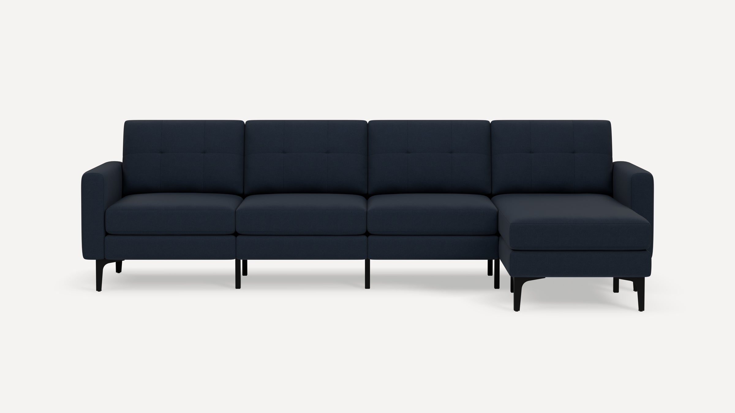 Modern dark blue sectional sofa with tufted back cushions, straight arms, and black legs against white background.