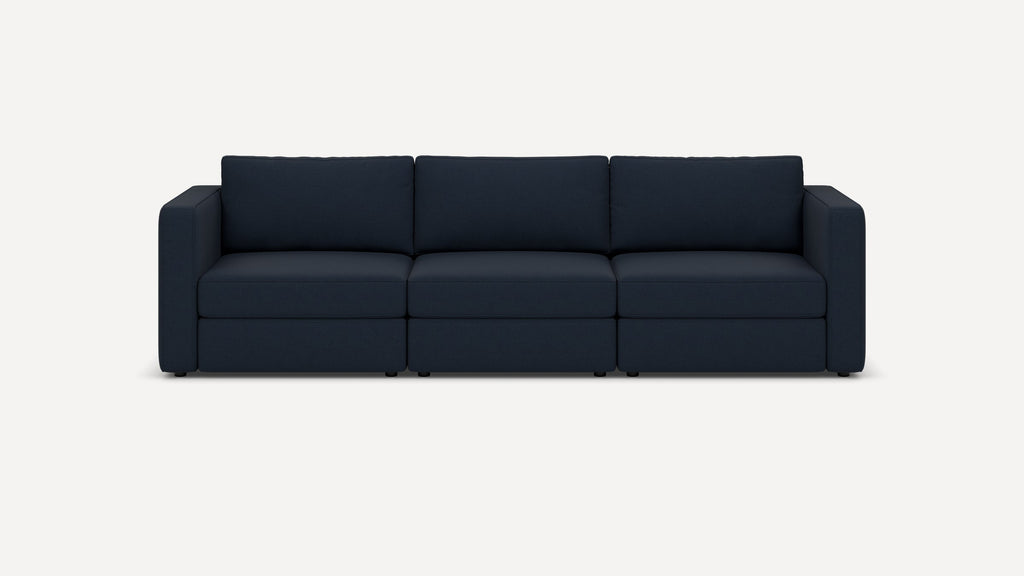 Modern navy blue fabric three-seater sofa with clean lines, boxy arms, and plush back cushions, set against a plain white background.
