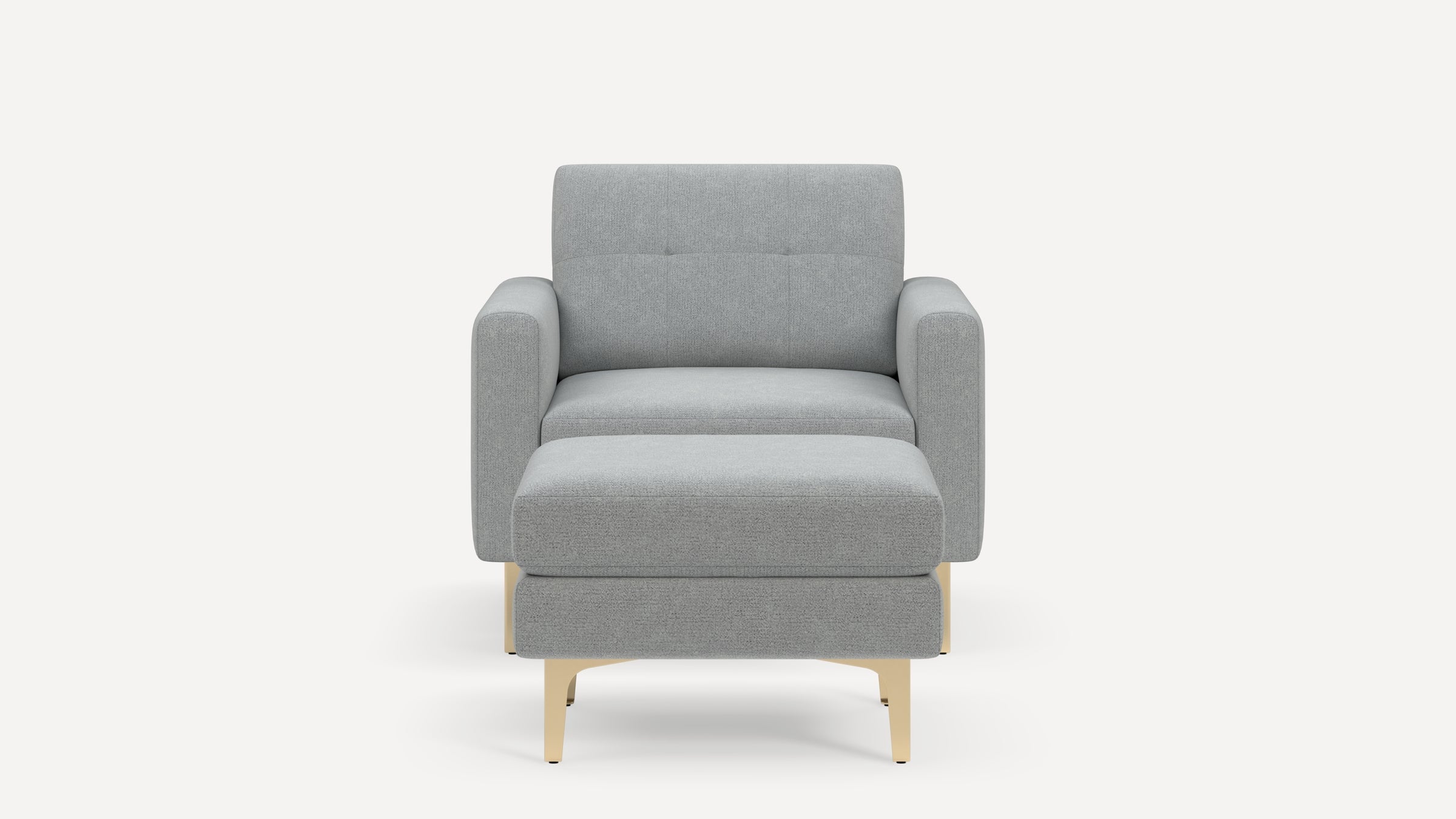 Front view of a modern light gray upholstered armchair with matching ottoman and beige legs on a white background.