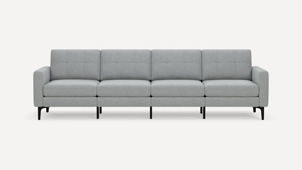 Modern light gray fabric four-seater sofa with clean lines, tufted back cushions, and black slim legs on white background.
