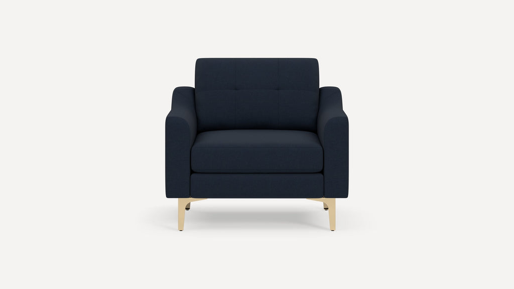 Modern navy blue armchair with cushioned seat and backrest, supported by light wooden legs on a white background.