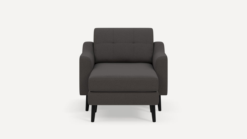 Front view of a modern dark gray upholstered armchair with padded armrests and black wooden legs against a plain white background.