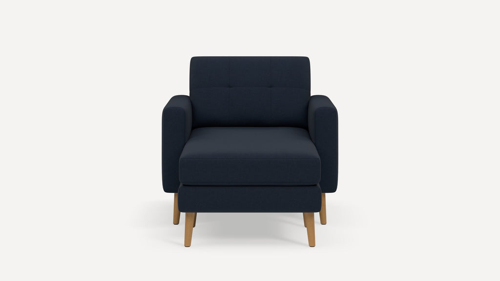 Front view of a modern navy blue armchair with wooden legs and cushioned seat and backrest.