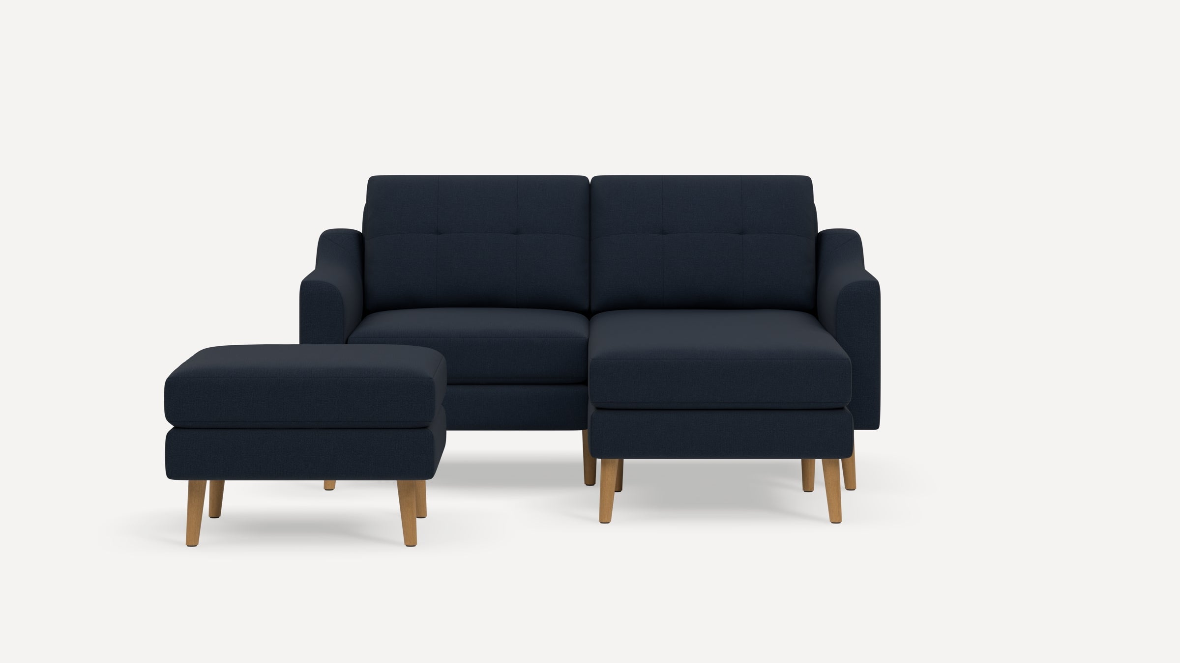 Modern navy blue fabric loveseat with two cushions and two matching wooden-legged ottomans on white background.