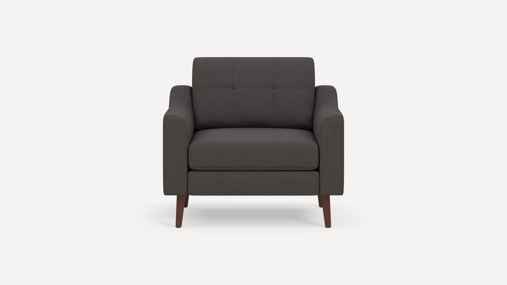 Front view of a modern dark gray upholstered armchair with tufted backrest and wooden legs on a white background.