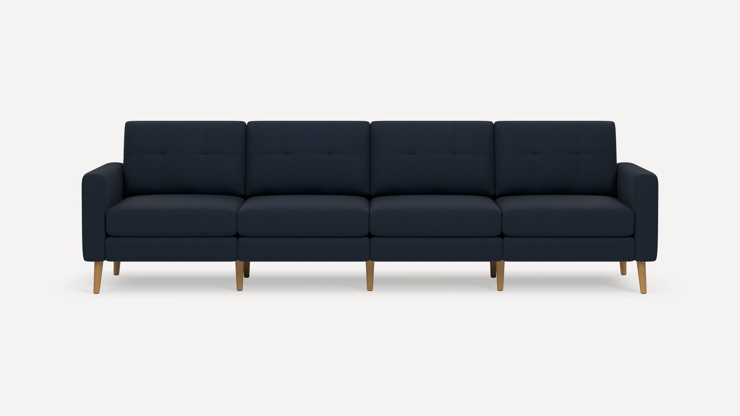Modern navy blue four-seater sofa with tufted back cushions and wooden legs on a plain white background.
