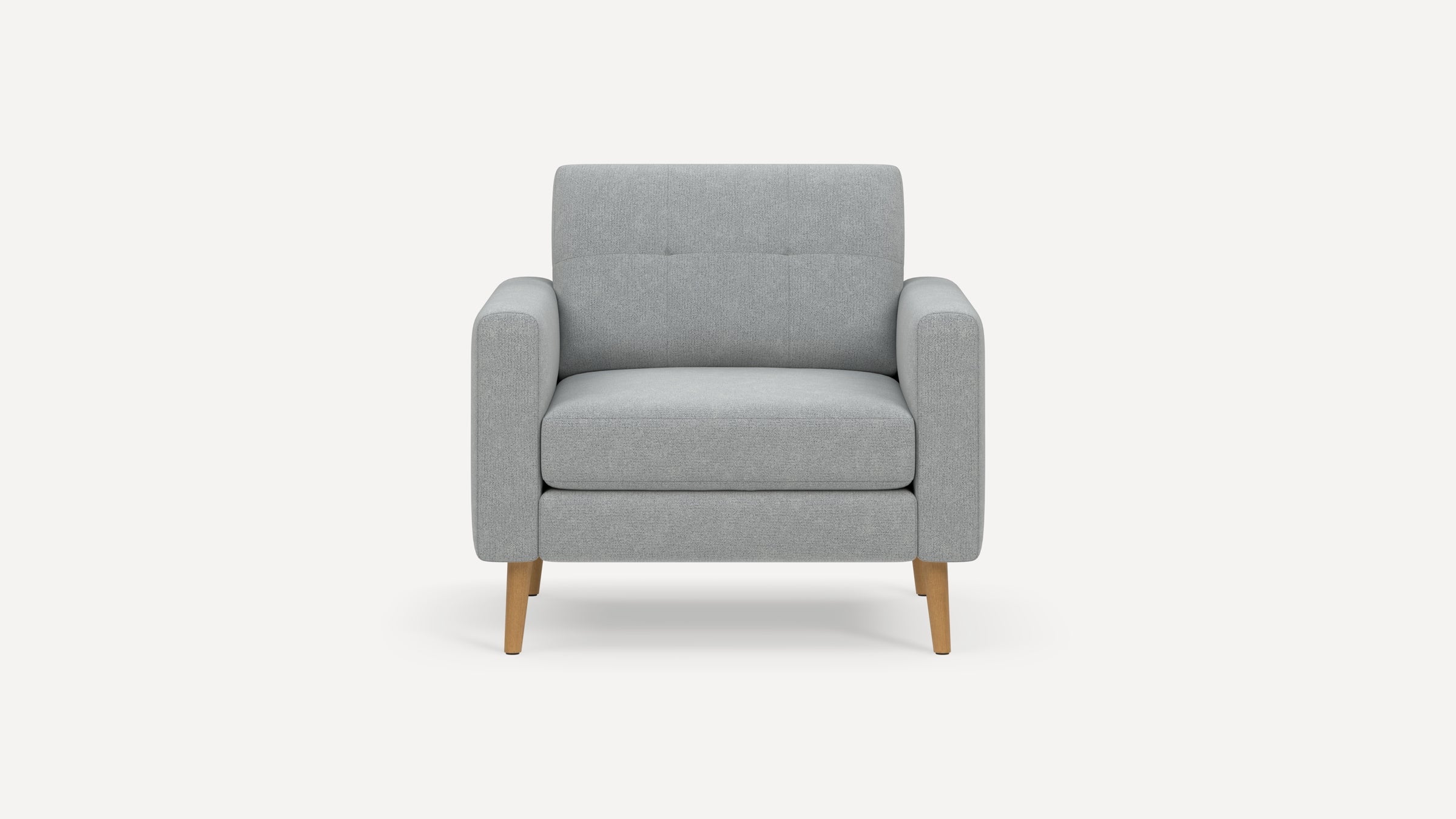 Light gray upholstered armchair with straight padded arms, tufted backrest, and wooden tapered legs on a white background.