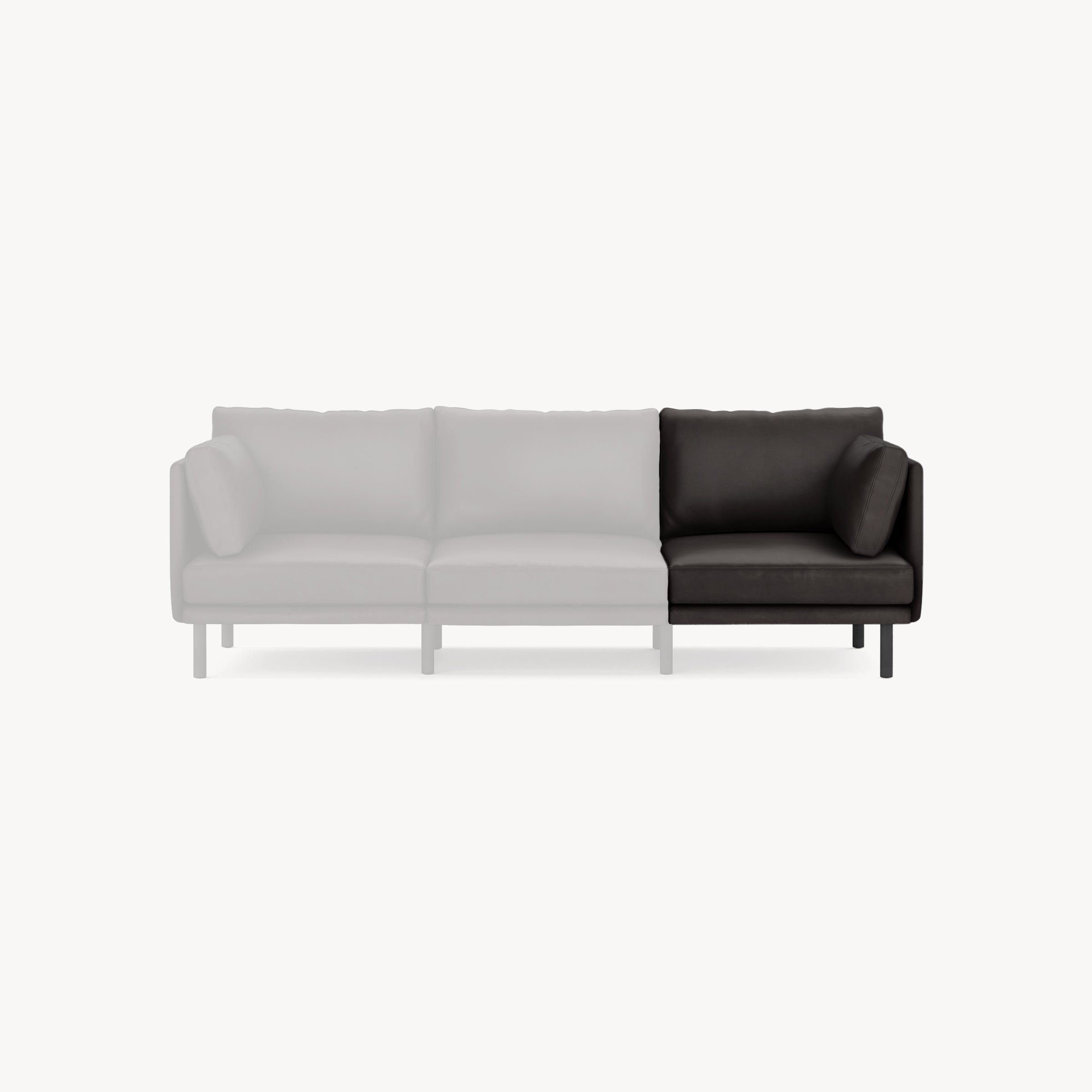 Right corner section of a modern black leather sofa with a single loose cushion against a plain white background.