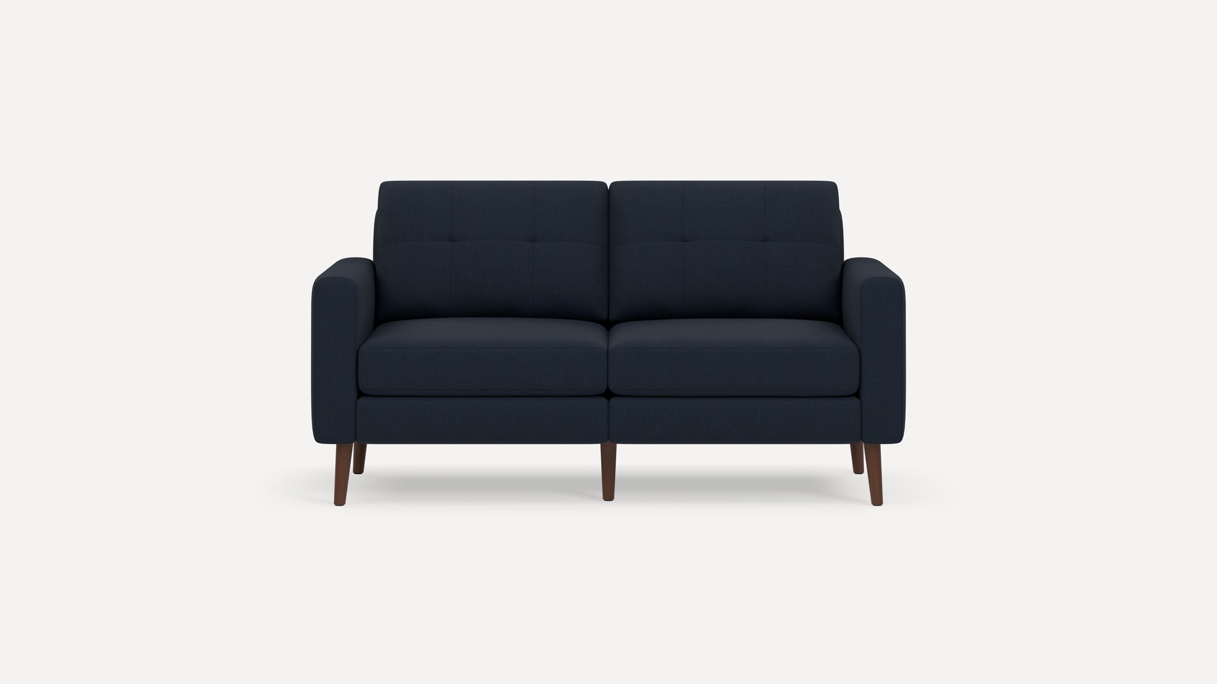Modern two-seater navy blue fabric sofa with tufted back cushions, padded armrests, and wooden tapered legs on white background.