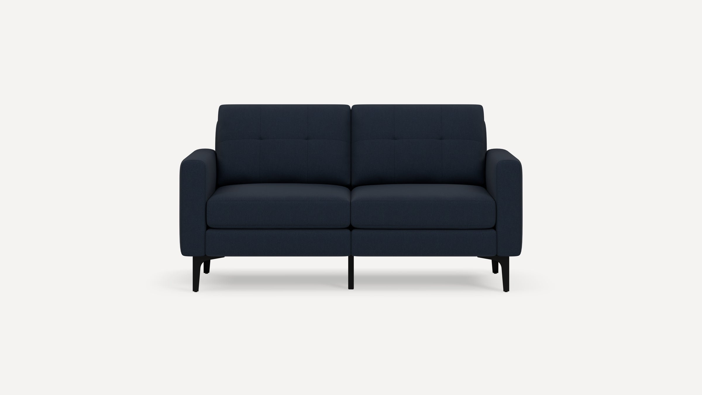 Modern navy blue two-seater sofa with tufted back cushions, plush seat cushions, rounded armrests, and slender black legs on white background.