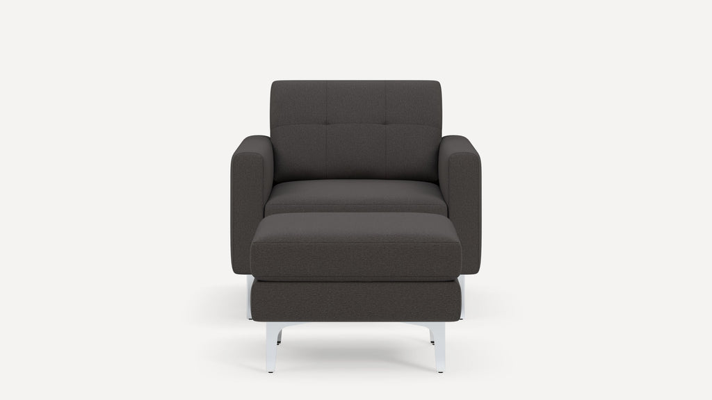 Front view of a modern dark gray upholstered armchair with matching ottoman, featuring clean lines and metal legs.