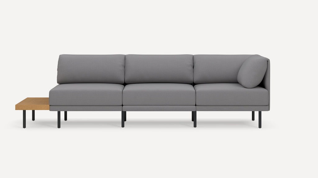 Modern gray three-seater sofa with a built-in wooden side table on black metal legs, featuring clean lines and a minimalistic design.