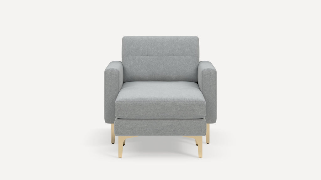 Front view of a modern light gray upholstered armchair with square arms and light wooden legs on a white background.
