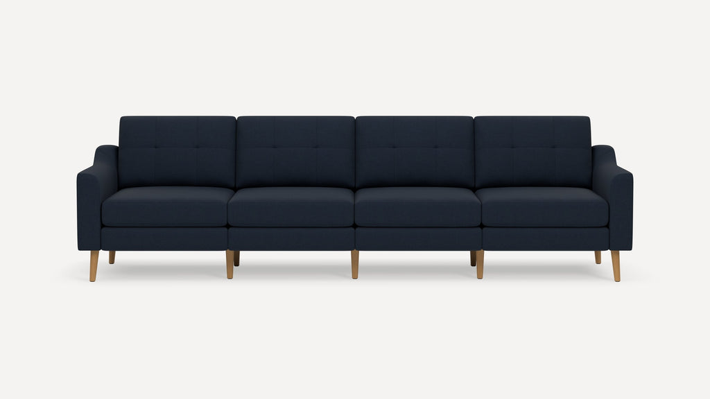 Four-seater modern navy blue fabric sofa with wooden legs and squared armrests, shown against a plain white background.