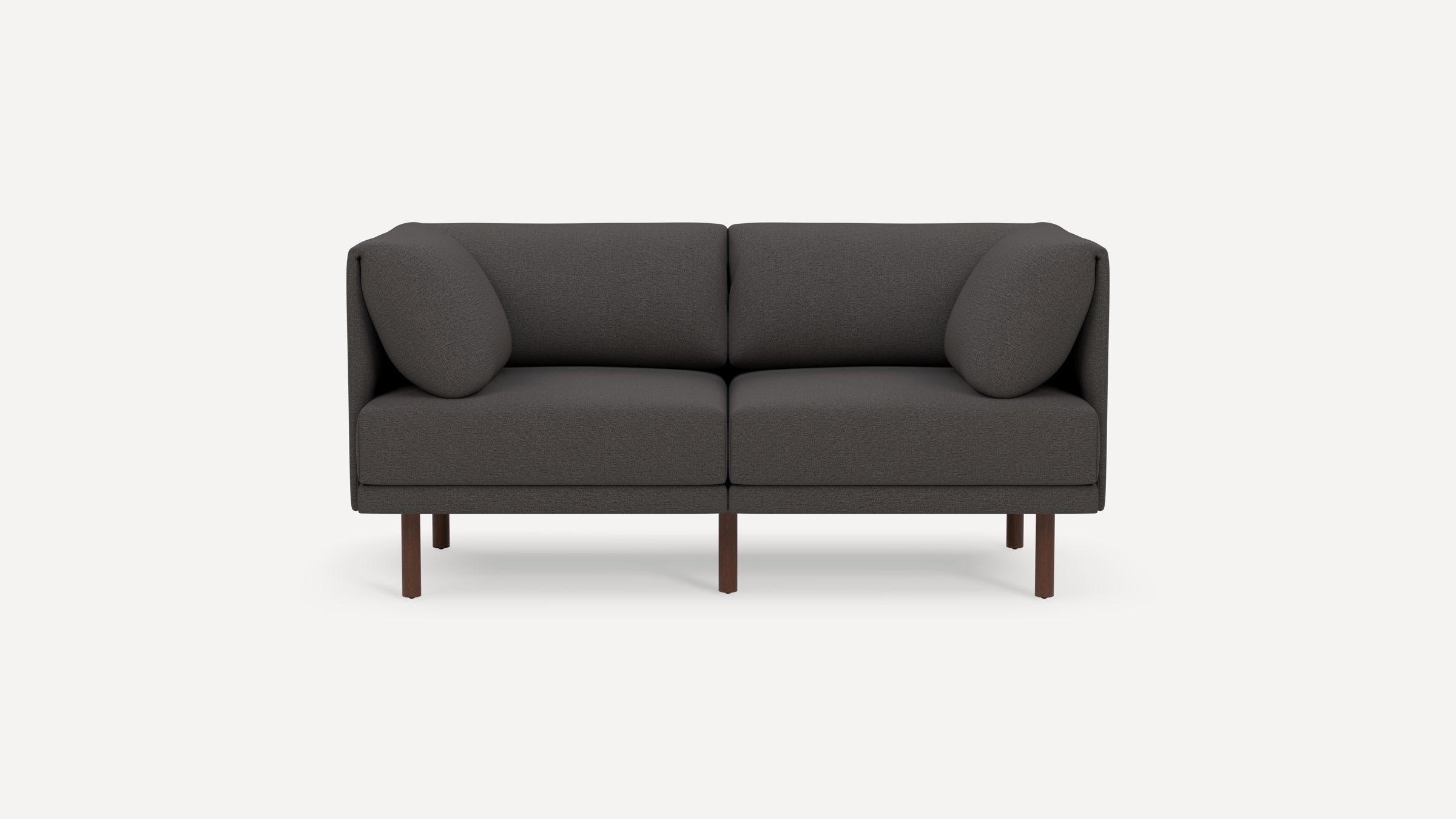 Modern dark gray two-seater sofa with rounded armrests and cushions, elevated on wooden legs, against a plain white background.
