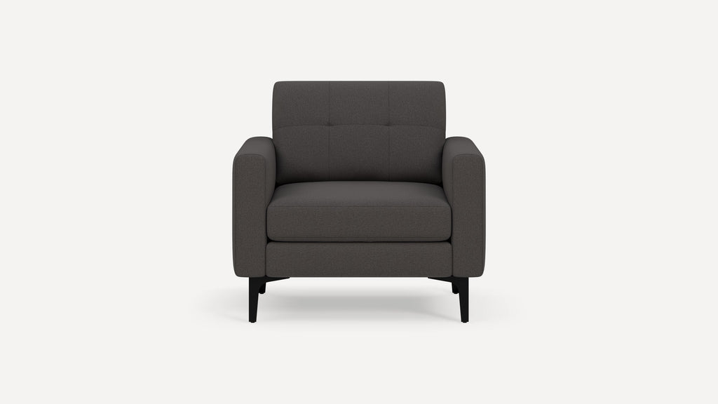 Dark gray upholstered armchair with tufted backrest and black slender legs, shown from the front on a plain white background.