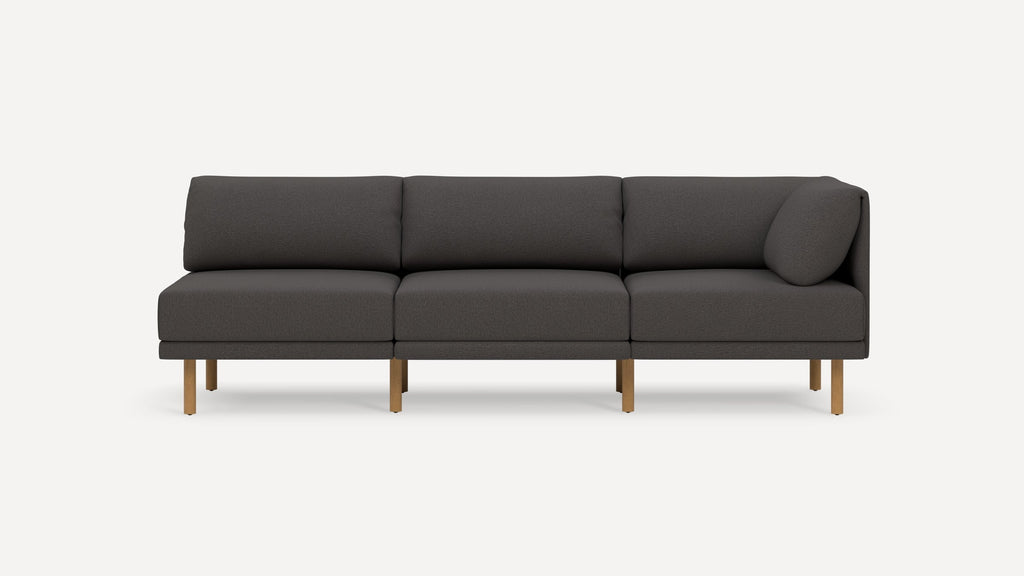Modern dark gray three-seater sofa with wooden legs, clean lines, and plush cushions against a plain white background.