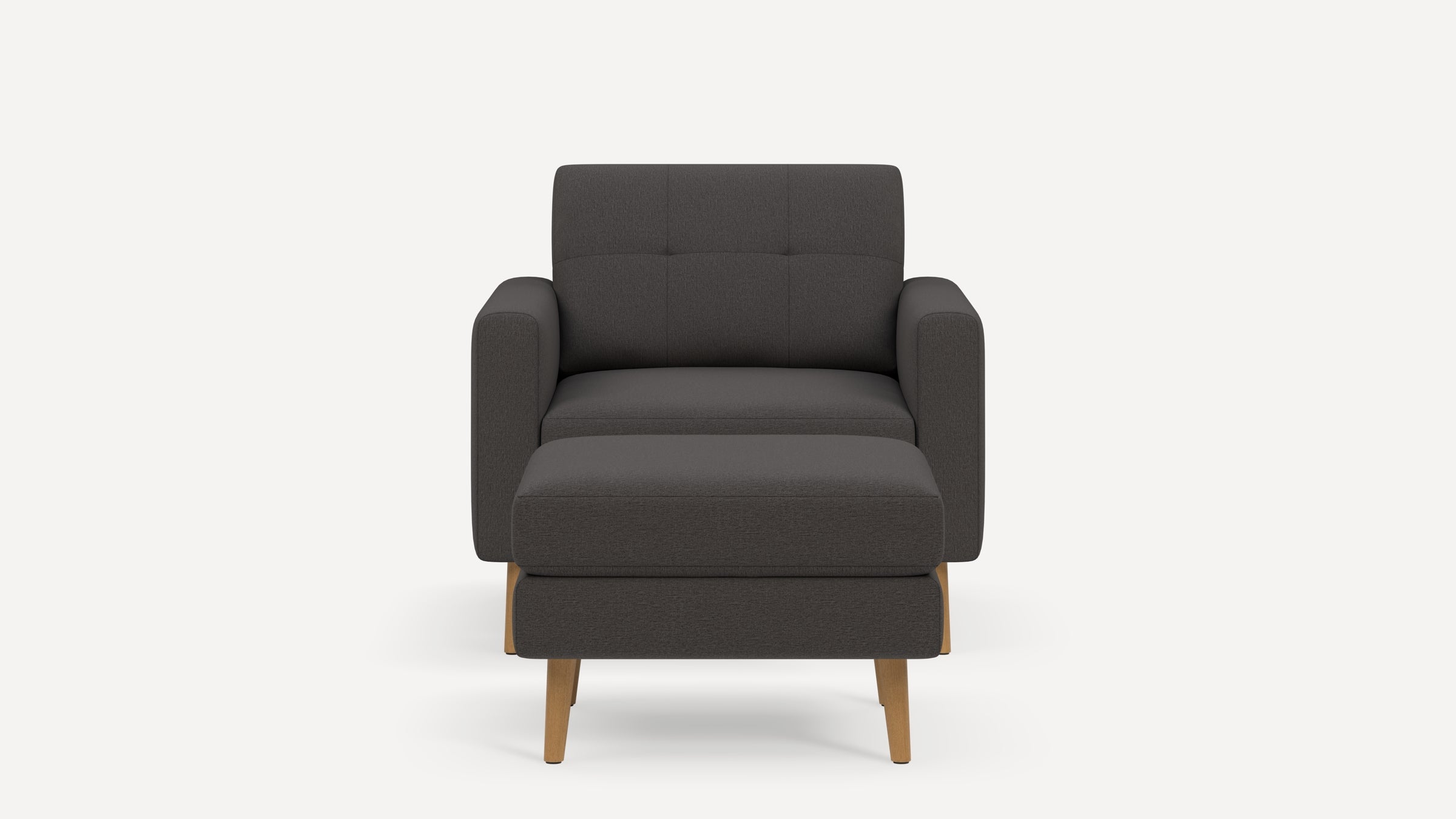 Front view of a modern dark gray armchair with matching rectangular ottoman and wooden legs on a white background.