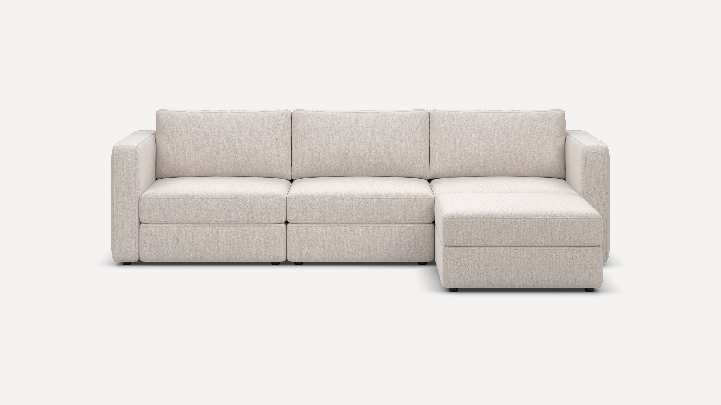 Modern three-seater sectional sofa with chaise lounge in light beige fabric upholstery, featuring clean lines and plush cushions.