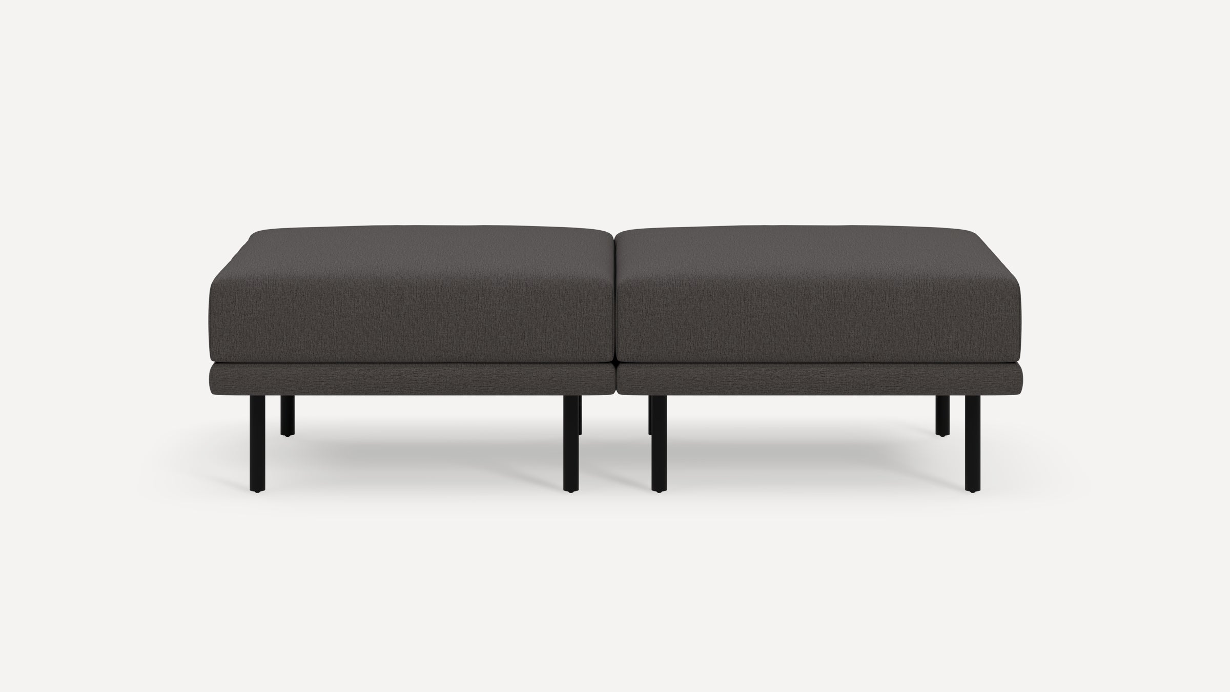 Modern dark gray upholstered rectangular ottoman with black metal legs, shown as two connected sections on a white background.