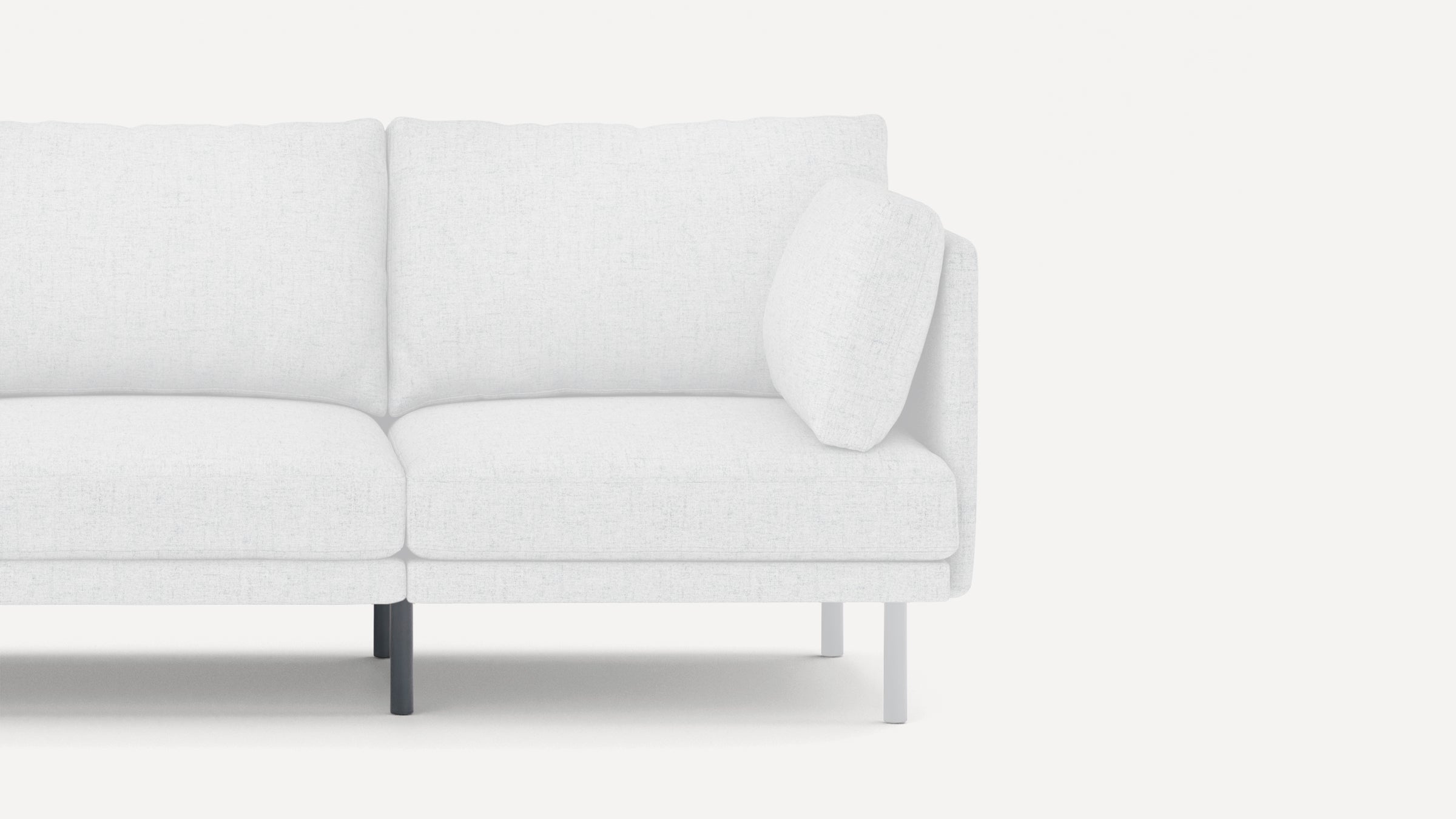 White modern sofa corner section with clean lines, plush cushions, and contrasting black and white legs on plain background.