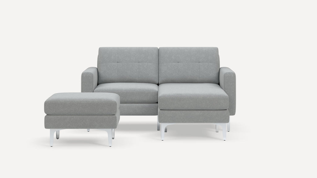 Modern light gray fabric sectional sofa with a matching ottoman, featuring clean lines and metal legs on a white background.
