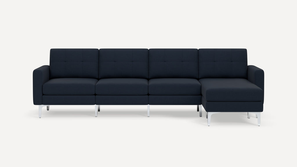 Modern dark blue sectional sofa with tufted back cushions, straight arms, and silver metal legs on white background.