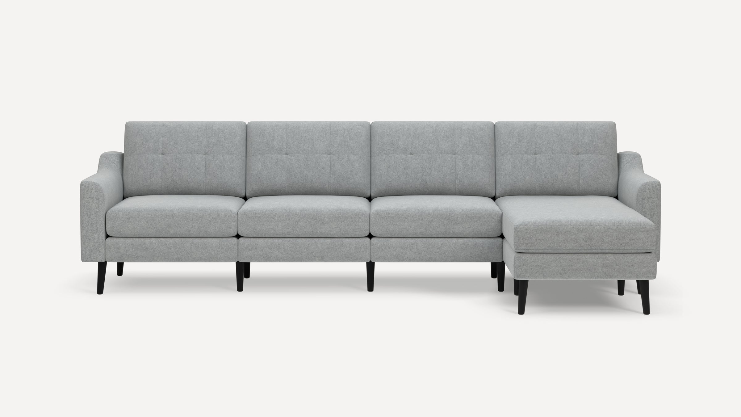 Light gray modern sectional sofa with tufted back cushions, black angled wooden legs, and right-side chaise lounge.