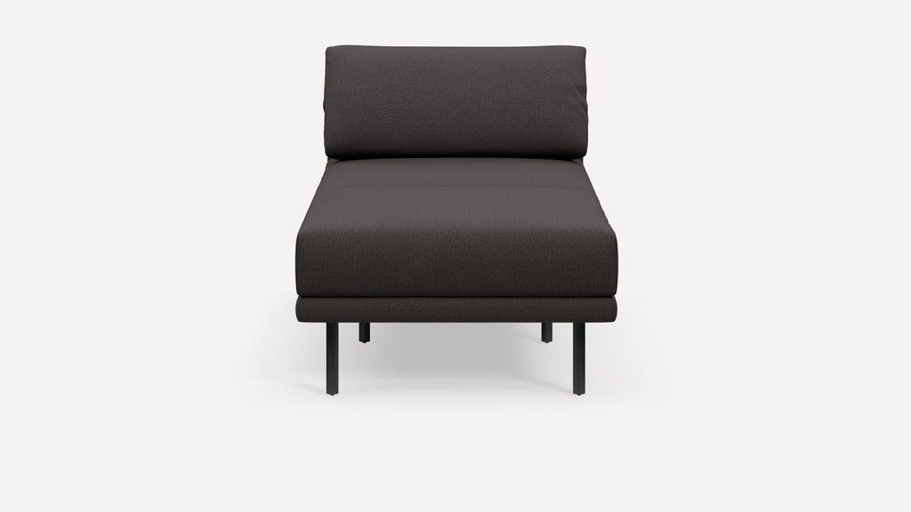 Modern minimalist dark gray chaise lounge with cushioned backrest and slim black metal legs, shown against white background.